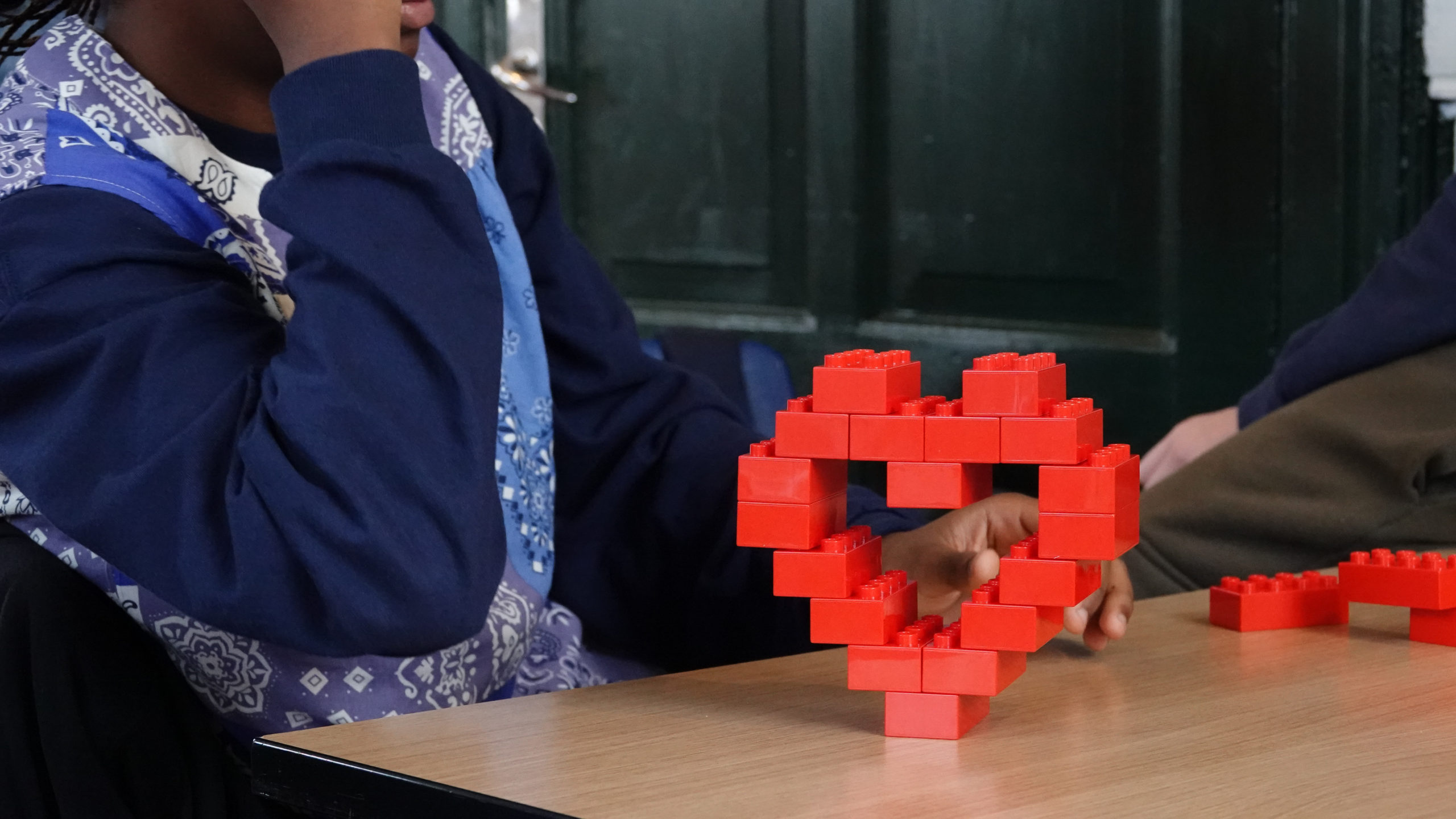 Elev med legoklodser formet som et hjerte